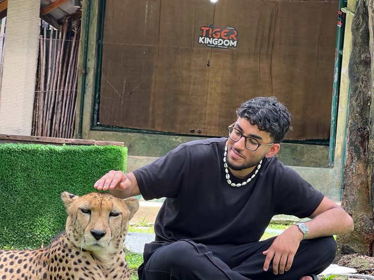 Aarham crouching beside a cheetah